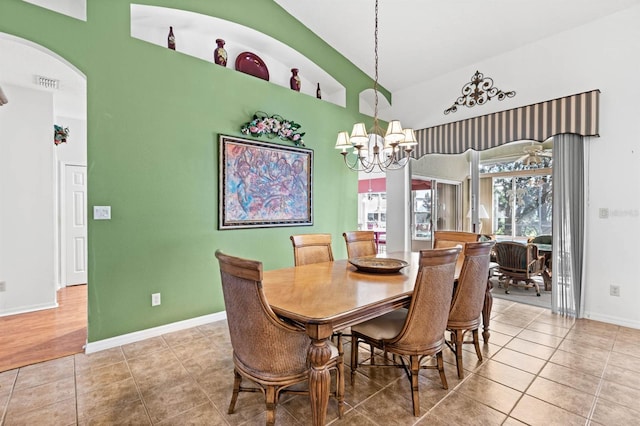 tiled dining room with a notable chandelier and lofted ceiling