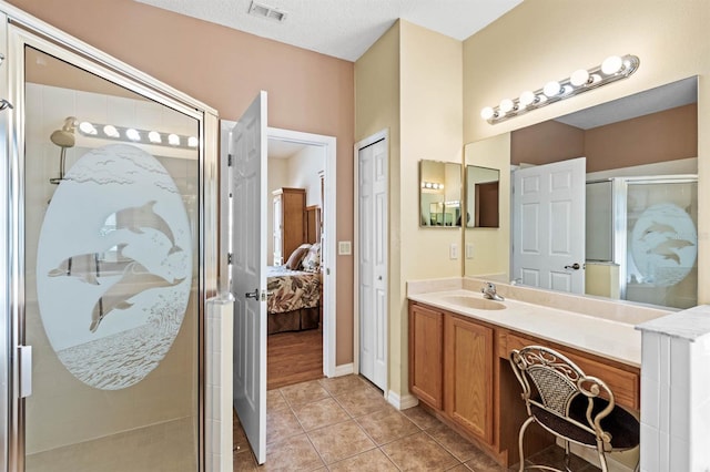 bathroom with tile patterned flooring, vanity, a shower with shower door, and a textured ceiling