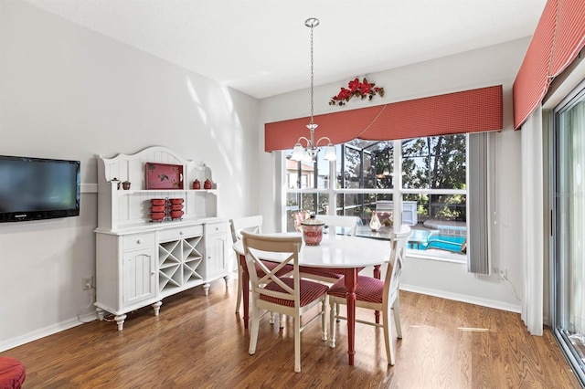 dining room with a notable chandelier, dark hardwood / wood-style floors, and plenty of natural light