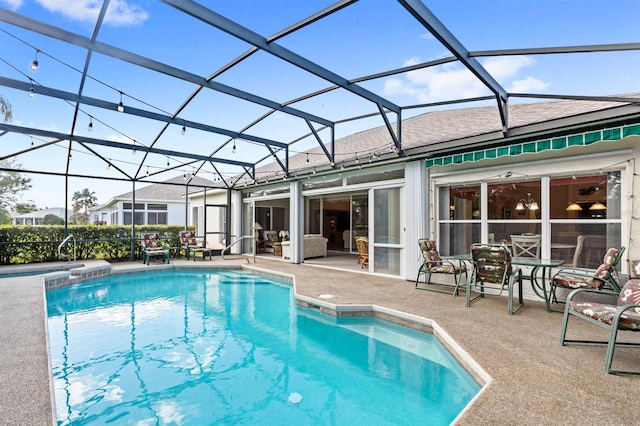 view of pool featuring glass enclosure and a patio