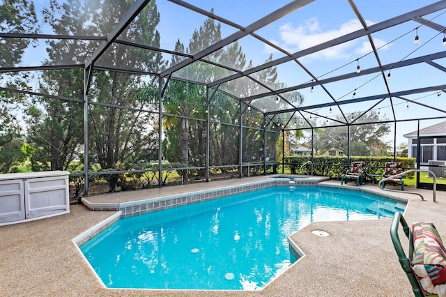 view of pool with a patio area and a lanai