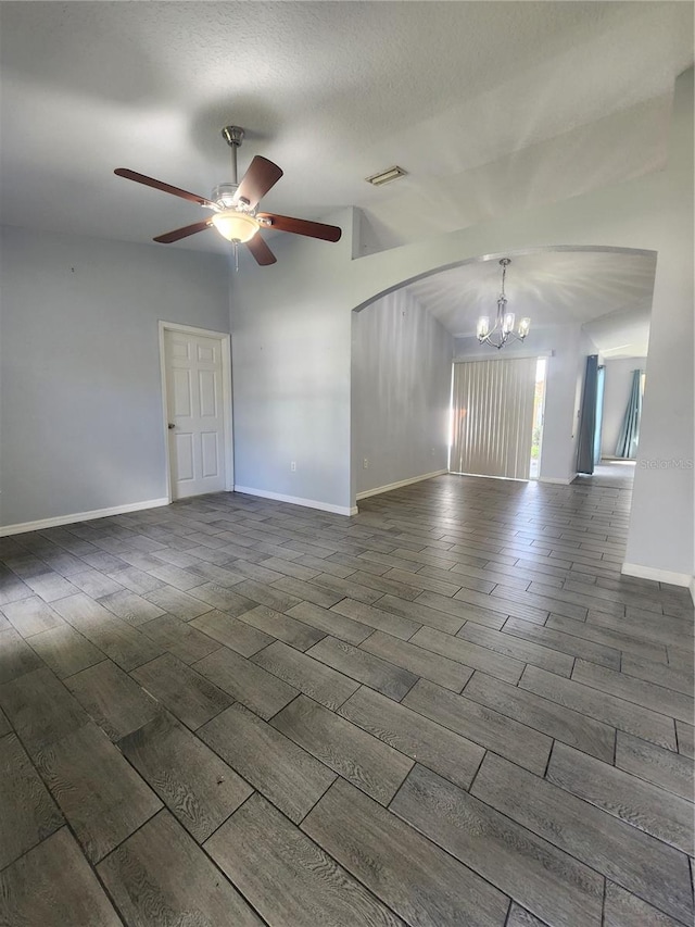 unfurnished room featuring a textured ceiling, ceiling fan with notable chandelier, lofted ceiling, and dark wood-type flooring