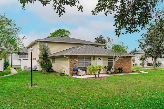 rear view of property with a patio and a yard