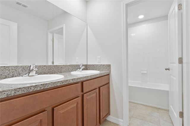 bathroom with tiled shower / bath combo, vanity, and tile patterned floors