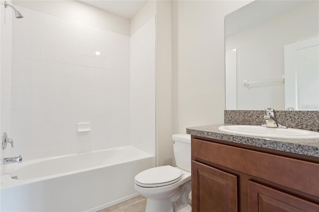 full bathroom featuring vanity, tiled shower / bath, and toilet