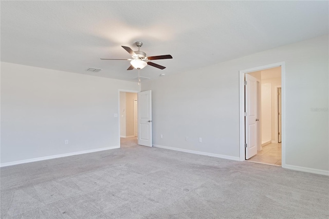 spare room featuring light carpet and ceiling fan