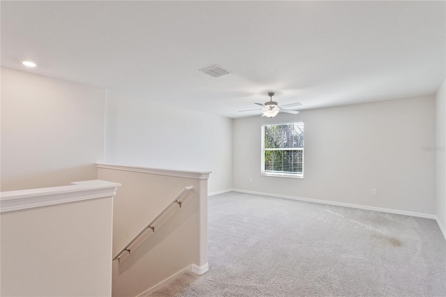 empty room featuring ceiling fan and light colored carpet