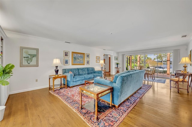 living room with light wood-type flooring and ornamental molding