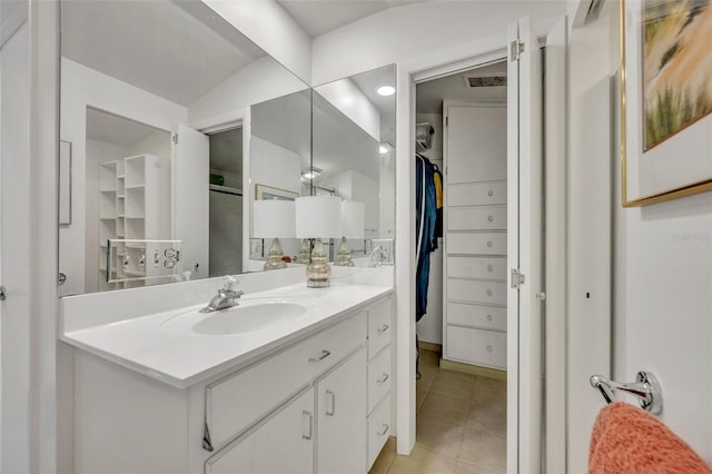 bathroom with vanity, vaulted ceiling, and tile patterned flooring