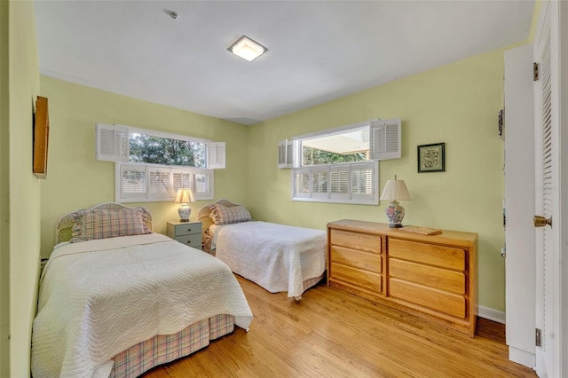 bedroom with light hardwood / wood-style floors and multiple windows