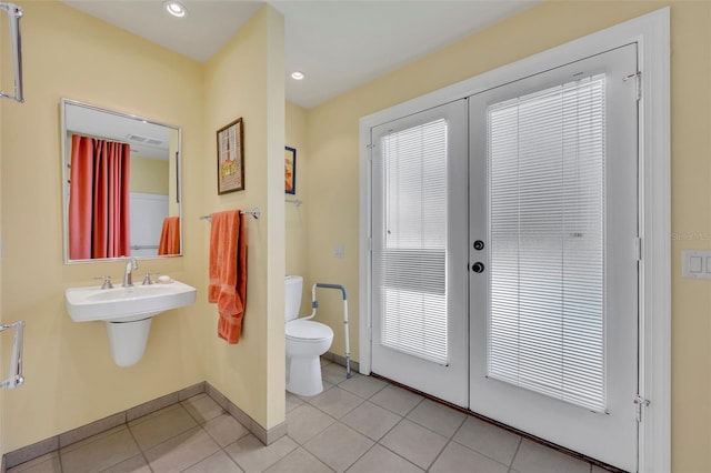 bathroom featuring french doors, tile patterned flooring, and toilet