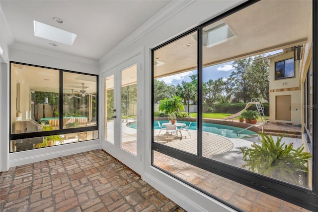 doorway featuring a skylight and crown molding