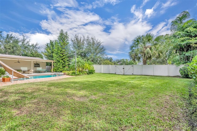 view of yard with ceiling fan and a fenced in pool