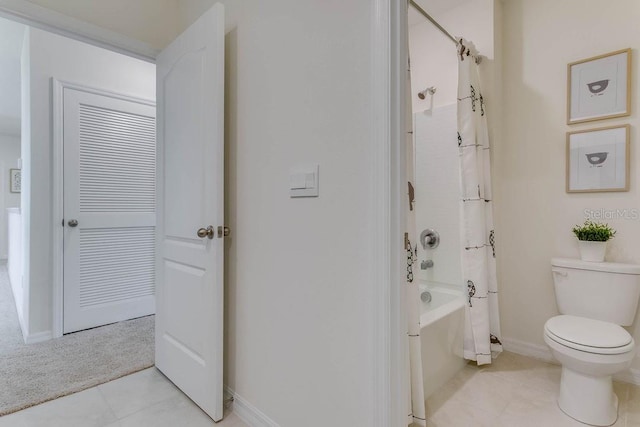 bathroom featuring tile patterned floors, shower / bathtub combination with curtain, and toilet