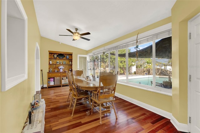 dining area with ceiling fan, wood-type flooring, and vaulted ceiling