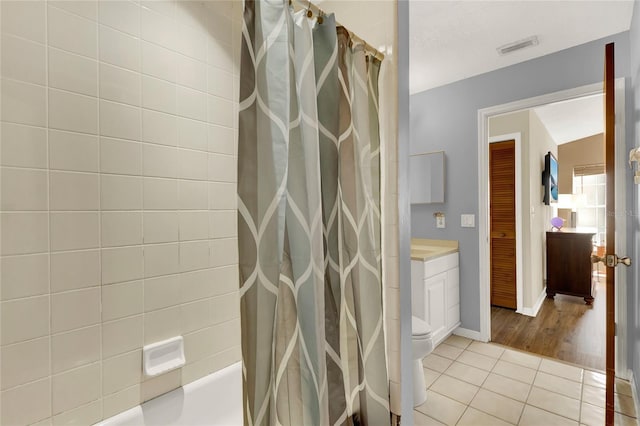 full bathroom featuring tile patterned floors, shower / tub combo with curtain, vanity, and toilet