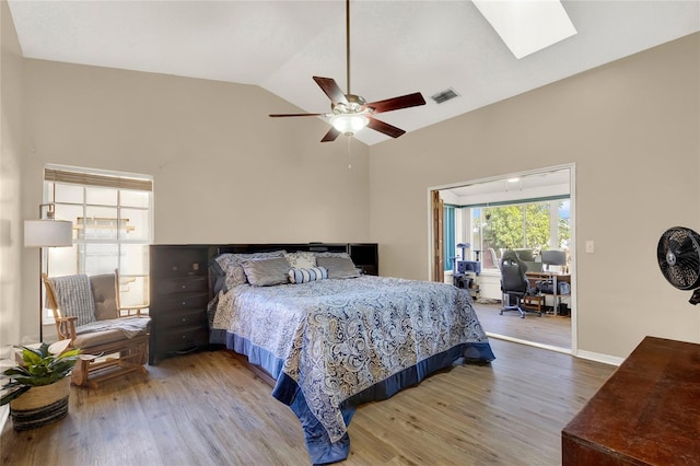 bedroom featuring ceiling fan, wood-type flooring, and lofted ceiling with skylight