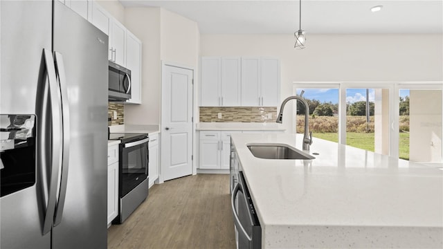 kitchen with white cabinets, sink, decorative light fixtures, and appliances with stainless steel finishes