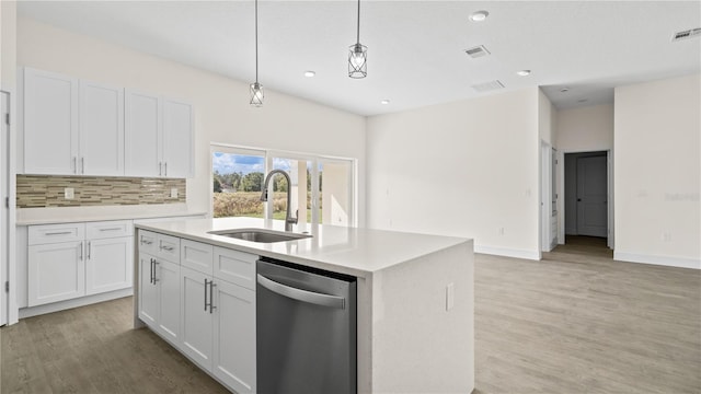 kitchen with a center island with sink, dishwasher, hanging light fixtures, sink, and white cabinetry