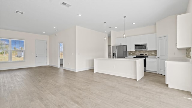 kitchen featuring light hardwood / wood-style flooring, a center island, pendant lighting, and stainless steel appliances