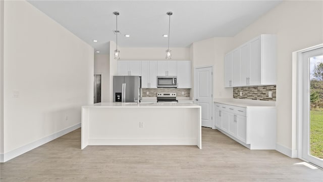 kitchen with white cabinetry, plenty of natural light, a kitchen island with sink, and appliances with stainless steel finishes