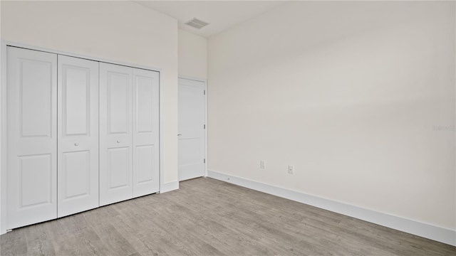 unfurnished bedroom featuring a closet and light wood-type flooring