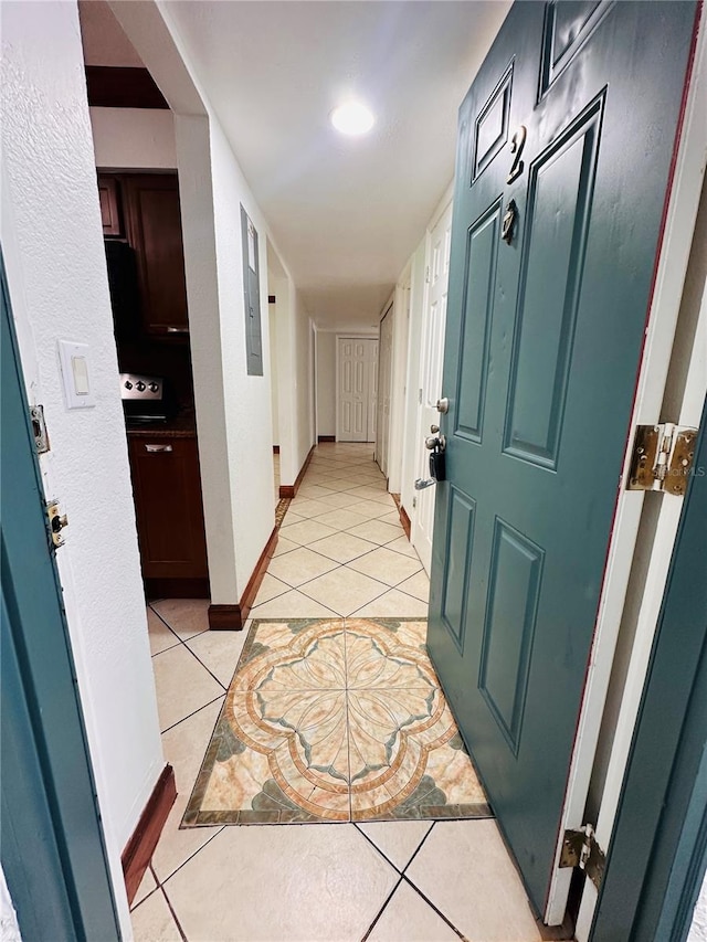 hall featuring electric panel and light tile patterned floors