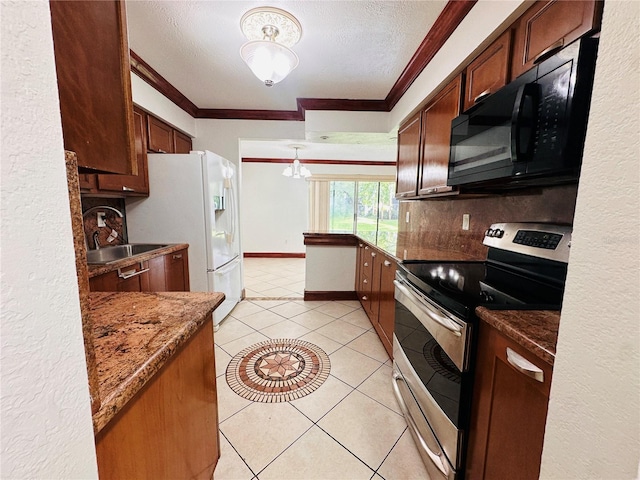 kitchen featuring light tile patterned flooring, sink, dark stone countertops, stainless steel range with electric cooktop, and hanging light fixtures