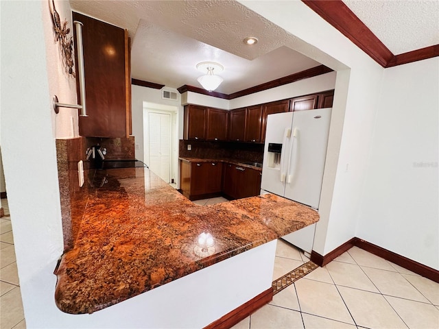 kitchen with decorative backsplash, kitchen peninsula, a textured ceiling, white refrigerator with ice dispenser, and light tile patterned flooring