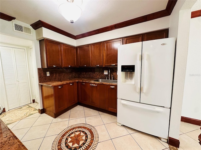 kitchen with sink, ornamental molding, tasteful backsplash, light tile patterned floors, and white refrigerator with ice dispenser