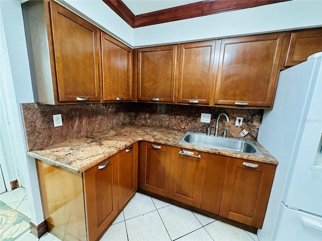 kitchen with stone countertops, sink, white refrigerator, and decorative backsplash