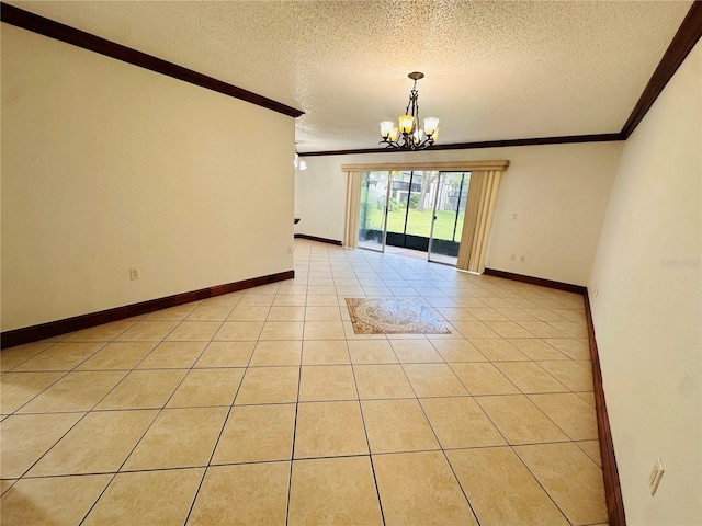 tiled spare room with a textured ceiling, crown molding, and a notable chandelier