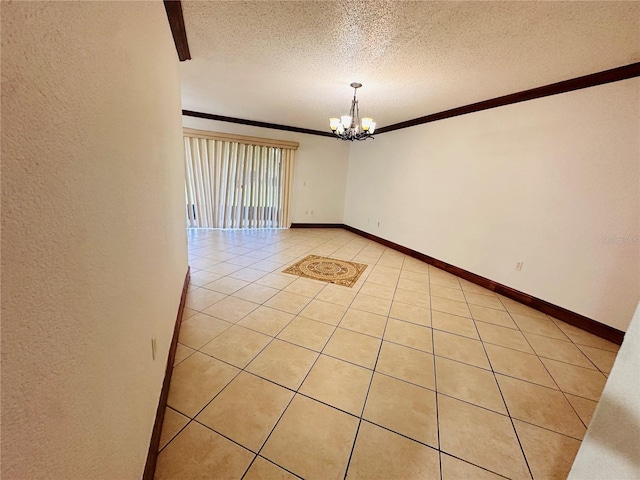 empty room with an inviting chandelier, a textured ceiling, light tile patterned floors, and ornamental molding