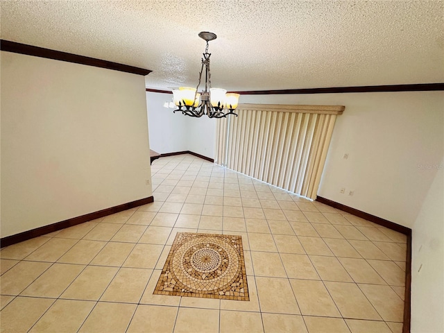 unfurnished dining area featuring light tile patterned floors, a textured ceiling, crown molding, and an inviting chandelier