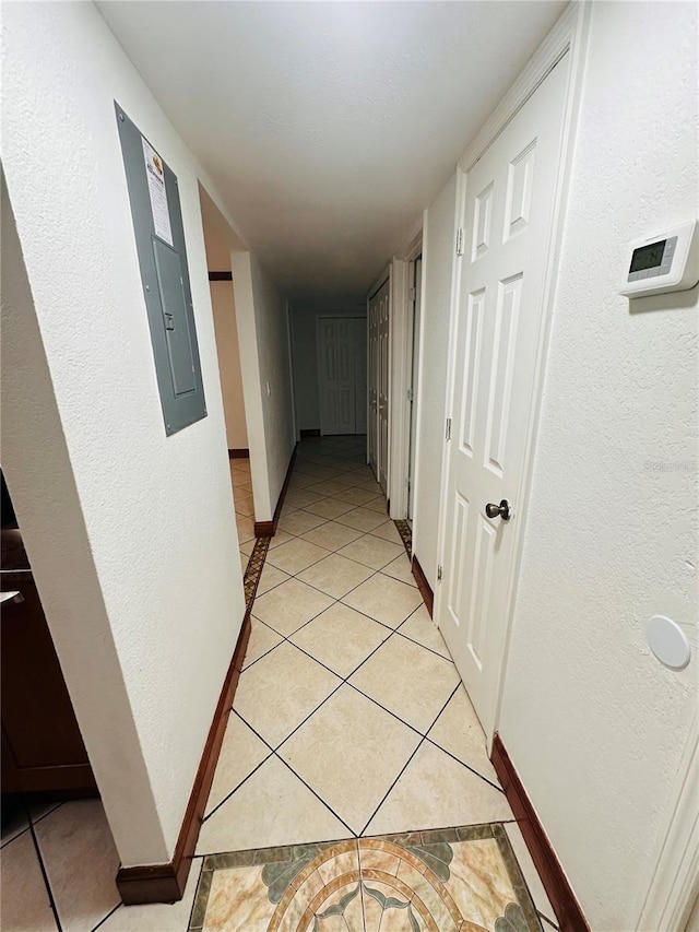 hall featuring electric panel and light tile patterned floors