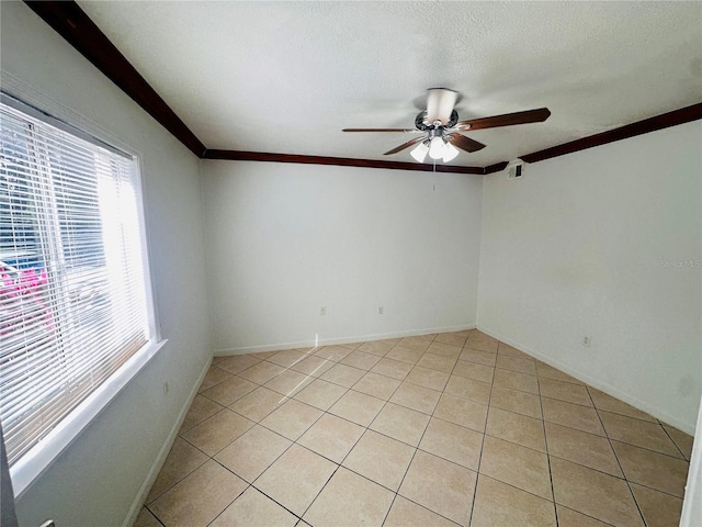 tiled empty room featuring a textured ceiling, ceiling fan, and crown molding