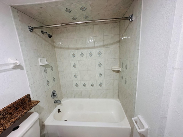 bathroom featuring tiled shower / bath and toilet