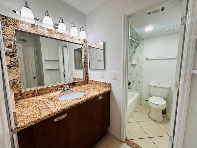 full bathroom with tile patterned flooring, vanity, tiled shower / bath combo, and toilet