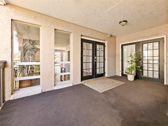 view of exterior entry featuring a patio area and french doors