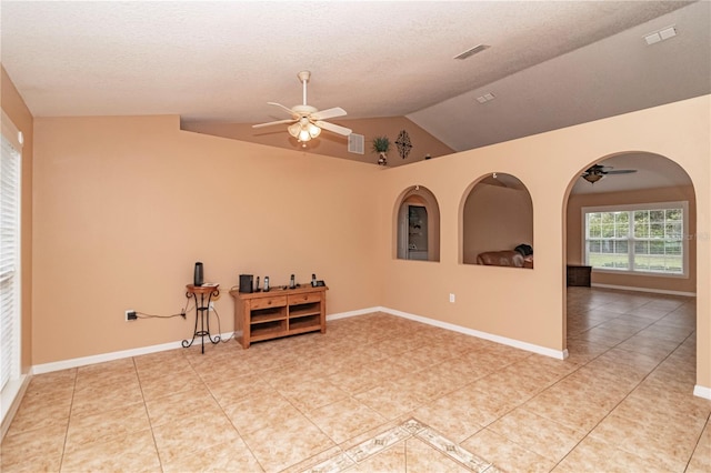 empty room featuring vaulted ceiling, tile patterned floors, and ceiling fan