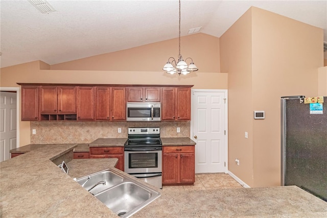 kitchen featuring decorative backsplash, sink, light tile patterned floors, pendant lighting, and appliances with stainless steel finishes