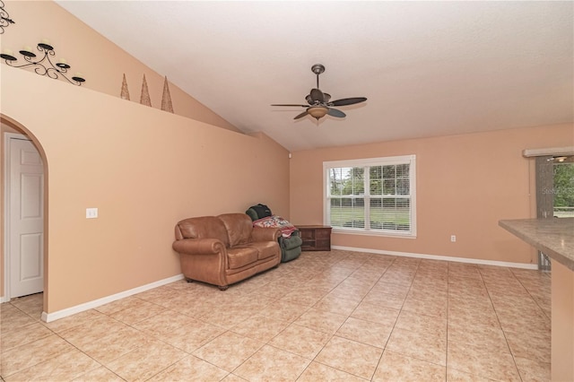 tiled living room with ceiling fan and vaulted ceiling