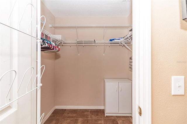 spacious closet featuring dark tile patterned floors