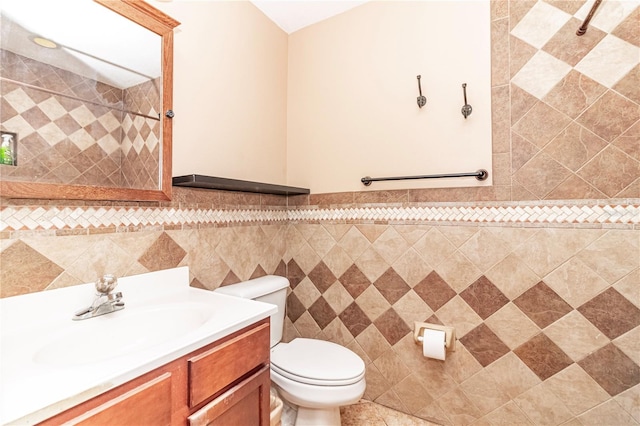 bathroom with toilet, vanity, tile walls, and walk in shower