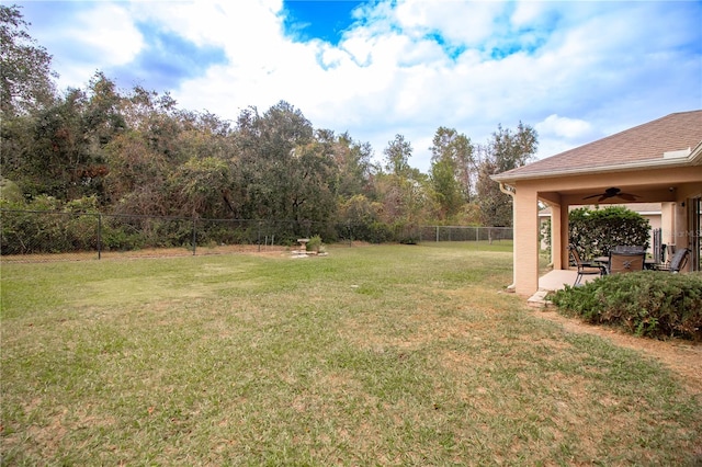 view of yard with ceiling fan and a patio