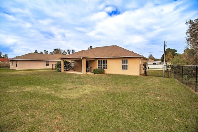 rear view of property with a lawn and a patio area