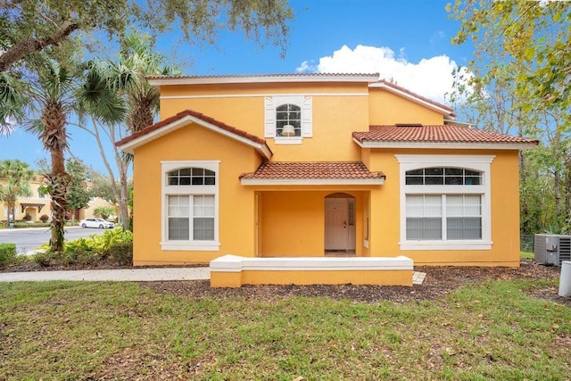 8447 Crystal Cove Loop, Kissimmee, FL 34747 - mediterranean / spanish-style home featuring central AC, a tiled roof, stucco siding, and a front lawn