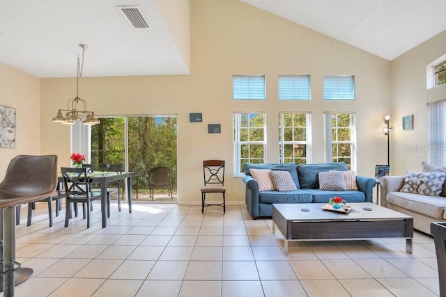 8447 Crystal Cove Loop, Kissimmee, FL 34747 - living area with high vaulted ceiling, light tile patterned floors, baseboards, a chandelier, and healthy amount of natural light