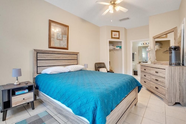 tiled bedroom with a closet, ceiling fan, and ensuite bath