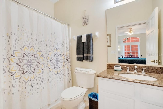 bathroom with walk in shower, vanity, ceiling fan, and toilet